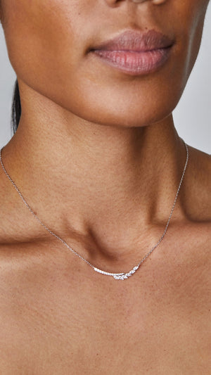 Delicate sterling silver pendant necklace, finished in white gold and embellished with a marquise-cut stones and micro-setting details.